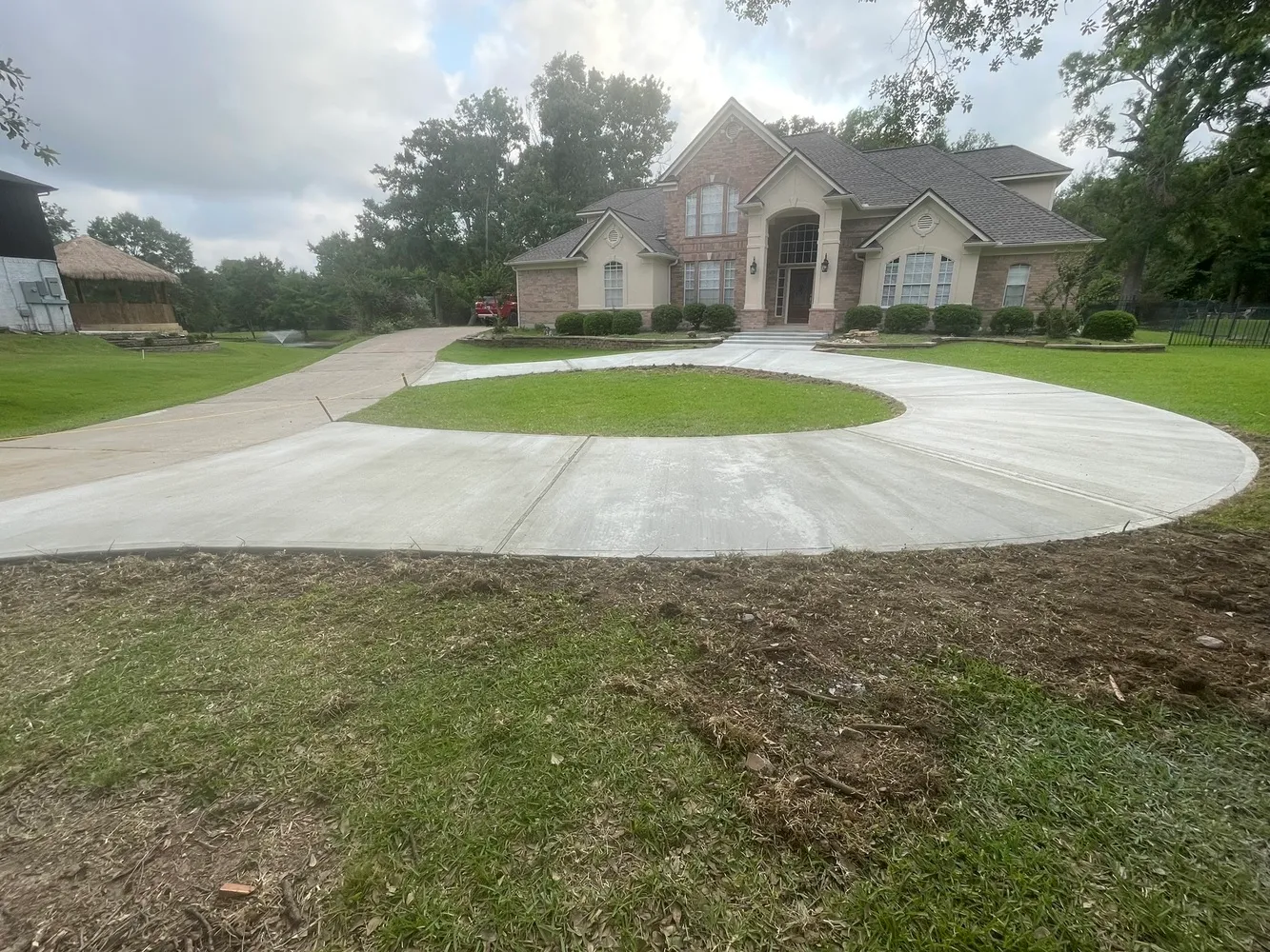 Curved concrete driveway with a grass island poured by Luck Concrete Lakeland
